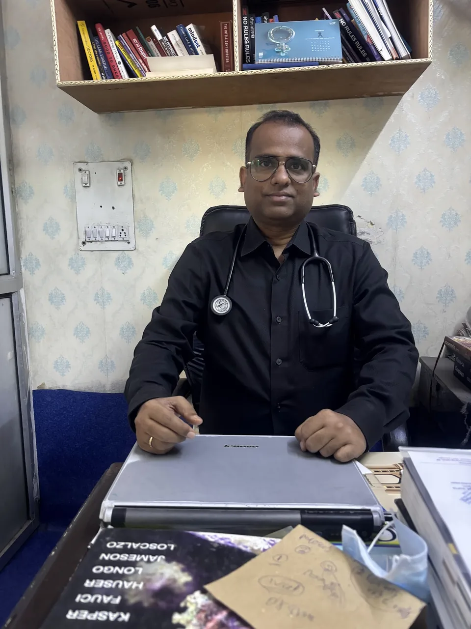 Dr. Rajesh Kumar Raman seated at his desk with a stethoscope