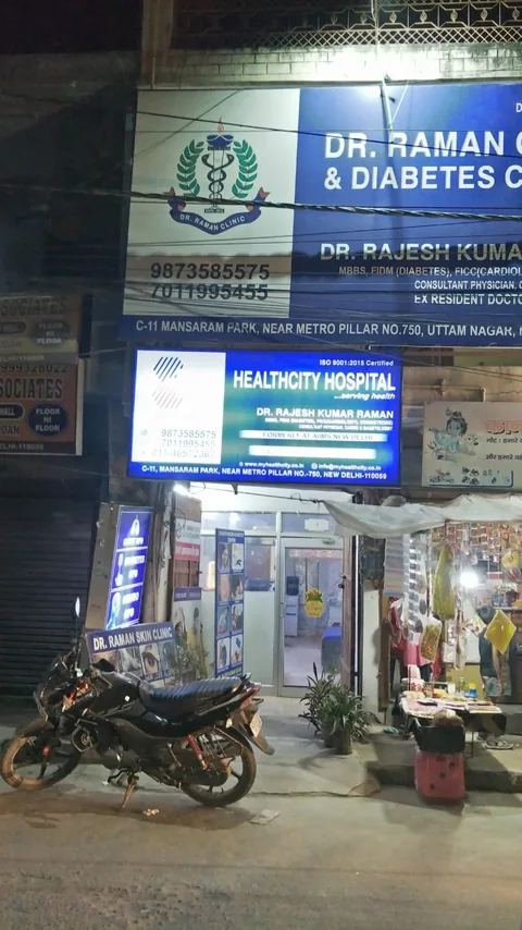 The clinic's illuminated board and entrance below the other boards on the street at night